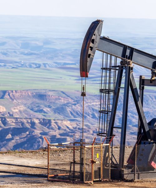 View of the pumpjack in the oil well of the oil field. Arrangement is commonly used for onshore wells producing little oil. It is overground drive for a reciprocating piston pump in an oil well.